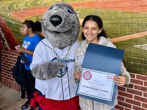 student posing with mascot